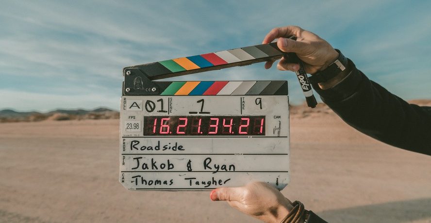mains qui tiennent un clap de cinéma
