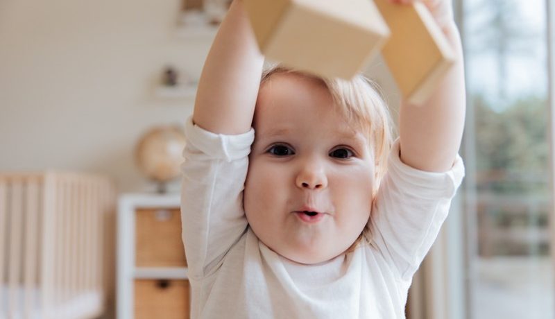 bébé qui tient un cube dans sa main