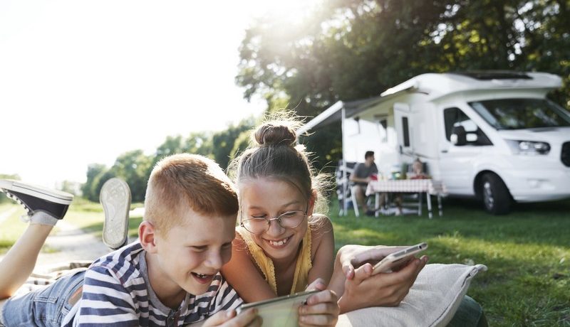 deux enfants qui jouent devant leur camping-car