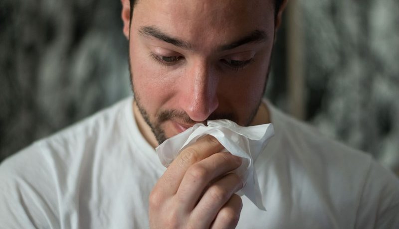 homme qui se mouche le nez
