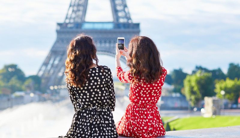 femmes qui se prennent en photo devant la tour eiffel
