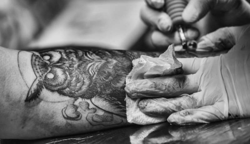 Un tatoueur qui tatoue une main