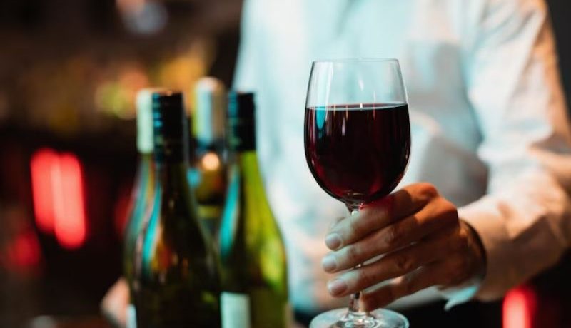 Un homme en train de tenir un verre de vin