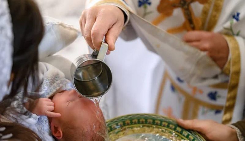 Un prêtre qui baptise un bébé