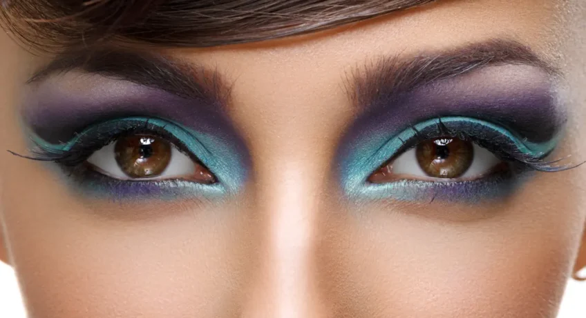 Une femme avec les yeux marrons et un maquillage bleu