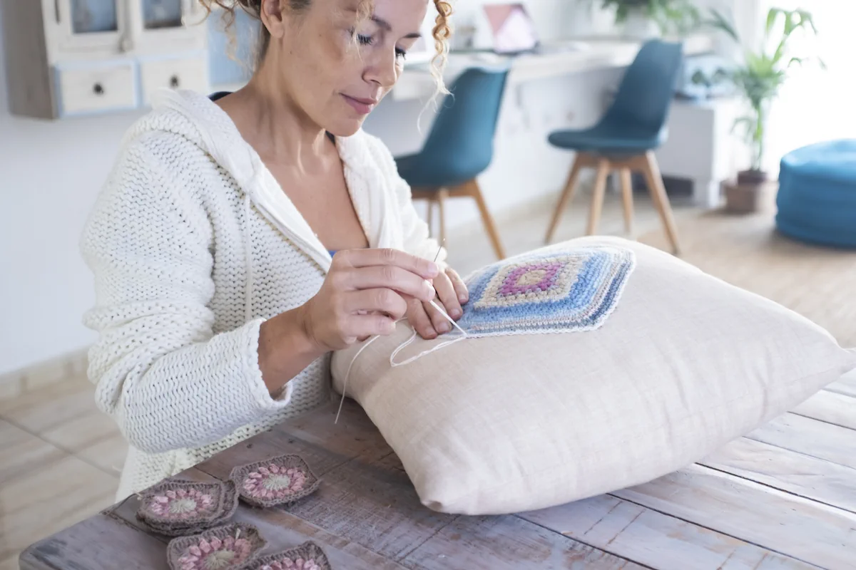 Une femme qui brode un coussin