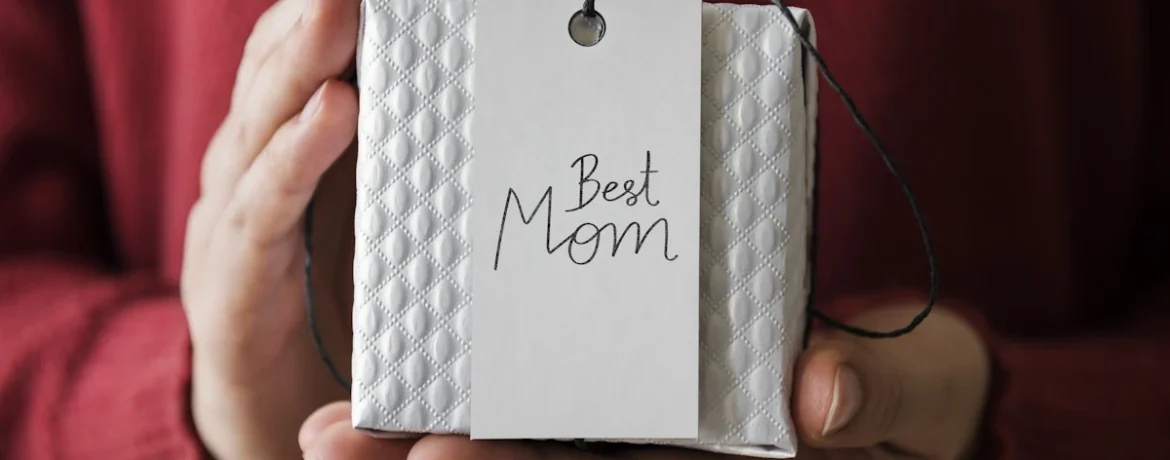 Une personne qui tient un paquet cadeau avec une étiquette best mom