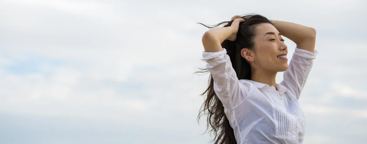 Une femme qui se tient la tête avec le sourrire