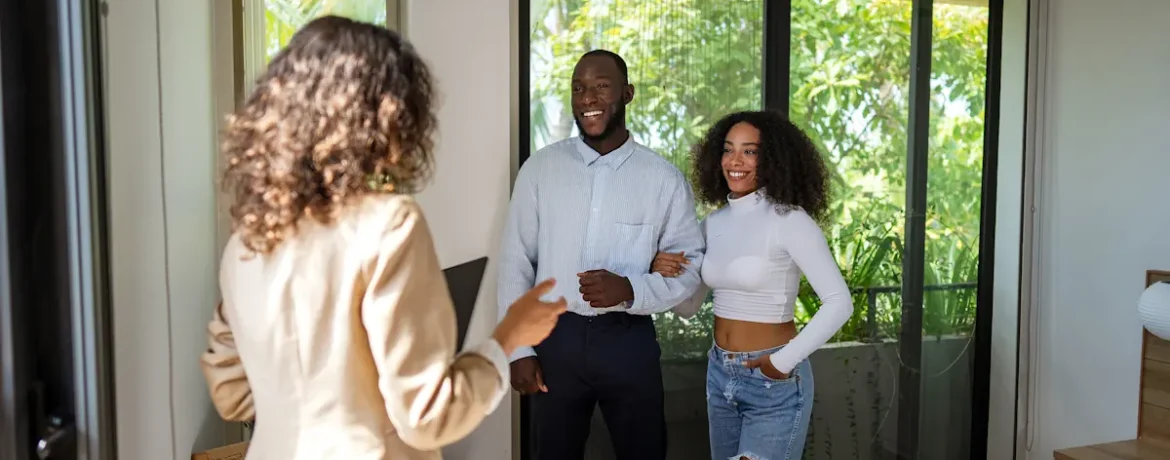 Un couple qui visite un bien avec l'aide d'une femme