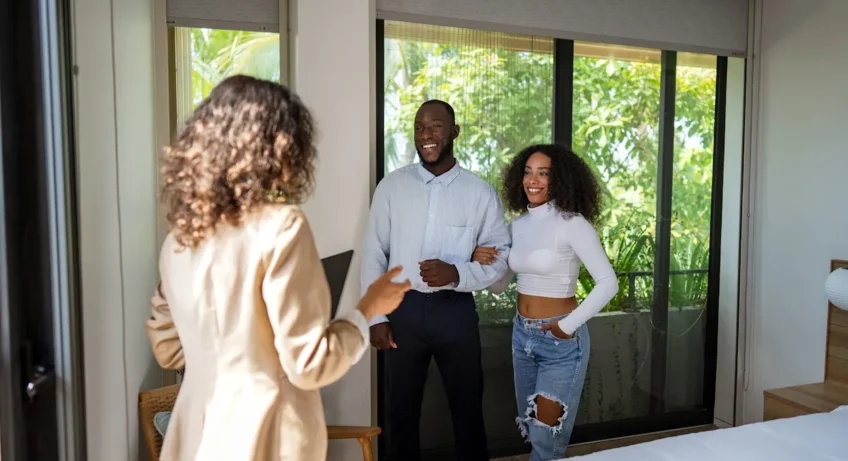 Un couple qui visite un bien avec l'aide d'une femme